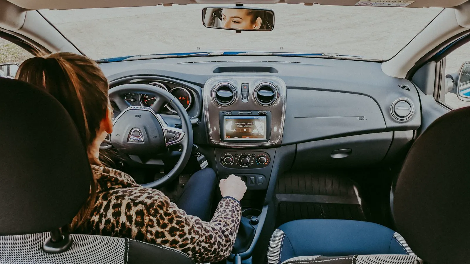 Mujer conduciendo sola de día, atenta al camino